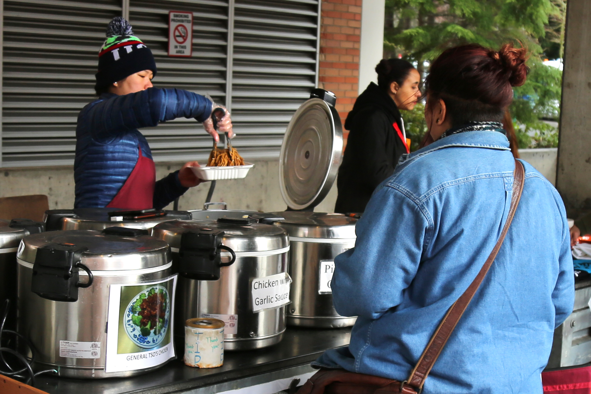 A vendor serves a student noodles outside the Viking Union.