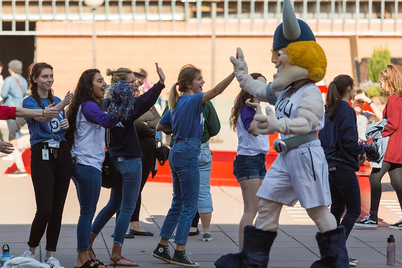 Viking Mascot high-fiving students in a line