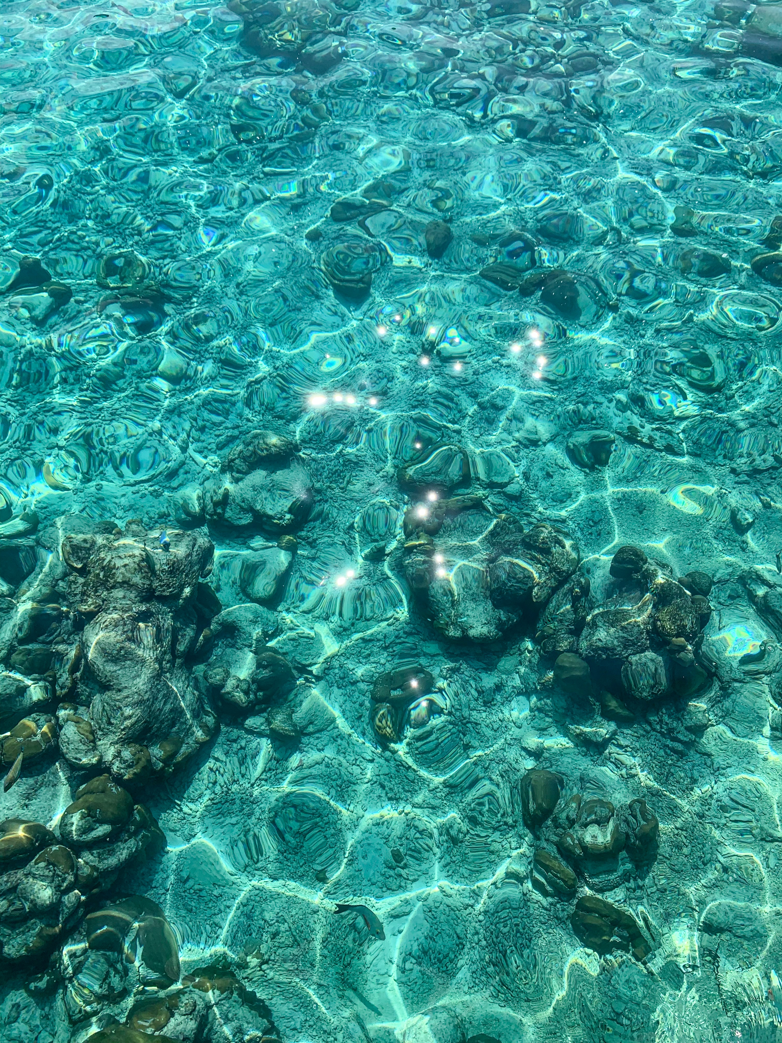 Turquoise sea floor with reflections from waves