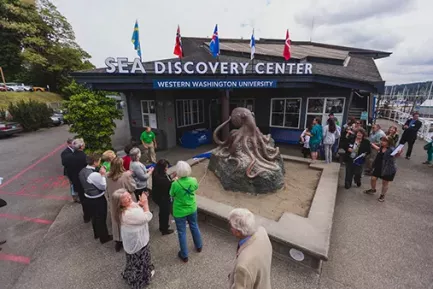 People gathered in front of an Octopus sculpture outside the SEA Discovery Center